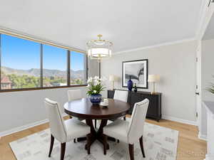 Dining room with a mountain view, light wood-style flooring, and crown molding