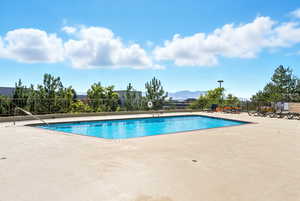 Community pool with a patio area and a mountain view