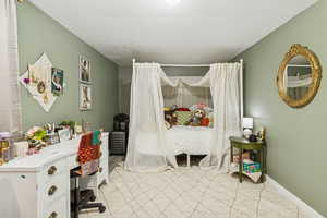 Bedroom featuring a desk and baseboards