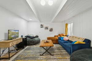 Living room featuring beamed ceiling and wood finished floors
