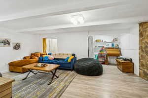 Living room featuring wood finished floors and beam ceiling