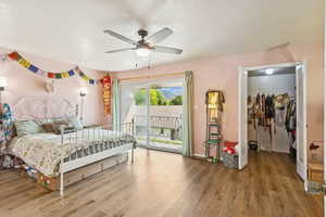 Bedroom featuring wood finished floors, access to outside, and ceiling fan