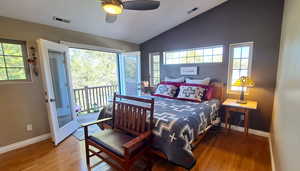 Bedroom with lofted ceiling, access to exterior, wood finished floors, and ceiling fan
