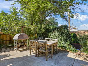 Fully fenced backyard featuring a patio area and outdoor dining spaces.