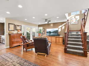 Living room featuring solid oak flooring, stairway, recessed lighting, and ceiling fan