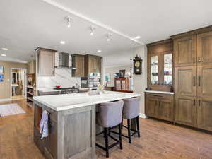 Sun-filled gourmet kitchen featuring high-end Thermador and Bosch appliances, including a double oven with a combi steam option. A large center island and open layout make it ideal for entertaining—stained wood cabinets, tile floors, and recessed lighti