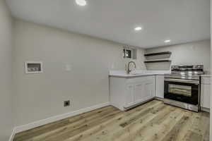 Kitchen featuring open shelves, electric range, white cabinets, recessed lighting, and light wood-type flooring