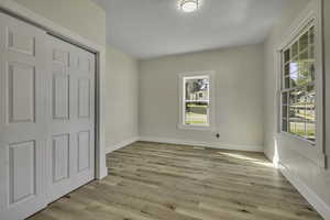 Unfurnished bedroom with light wood-style floors and a closet