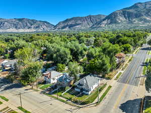 Aerial view of residential area featuring a mountain backdrop and a heavily wooded area