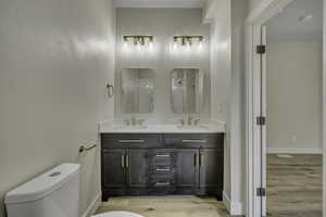Bathroom with double vanity, light wood finished floors, and a shower