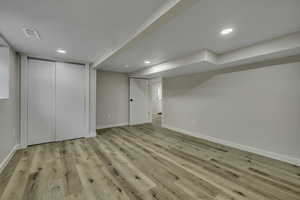 Finished basement featuring light wood-type flooring and recessed lighting