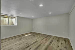Spare room with recessed lighting, light wood-type flooring, and a textured ceiling