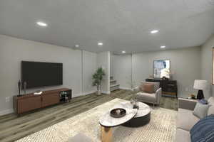Living room featuring wood finished floors, recessed lighting, a textured ceiling, and stairs
