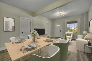 Dining room with a textured ceiling, wood finished floors, and beam ceiling