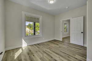 Unfurnished room featuring light wood finished floors and baseboards