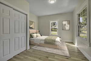 Bedroom featuring light wood-type flooring and a closet