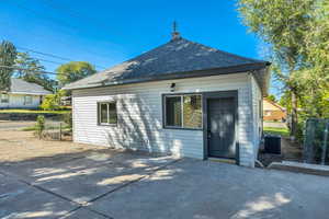 Back of property featuring roof with shingles and a chimney
