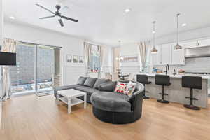 Living area featuring a chandelier, light wood-style flooring, recessed lighting, and a ceiling fan