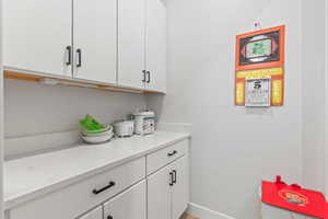 Pantry featuring white cabinetry and light stone counter