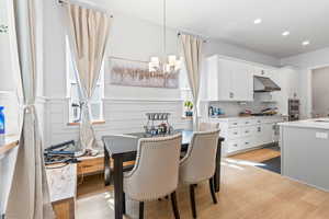 Dining room featuring light wood-style floors, a chandelier, and recessed lighting