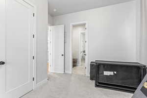 Bedroom featuring light colored carpet and baseboards