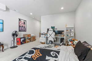 Carpeted bedroom with recessed lighting and an office area