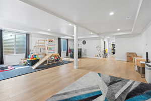 Family room with light wood-style flooring and recessed lighting