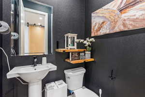 Bathroom with toilet and a textured wall