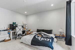 Bedroom featuring light colored carpet, an office area, and recessed lighting