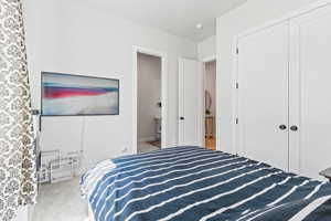 Bedroom with light carpet and a closet