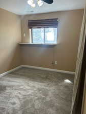 Spare room featuring light carpet, a textured ceiling, and ceiling fan