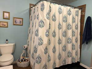 Bathroom with a shower with curtain and dark tile patterned floors
