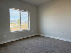 Carpeted spare room featuring a mountain view and baseboards
