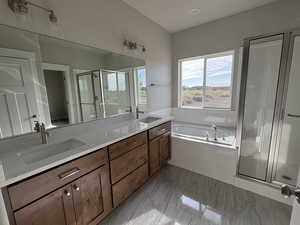 Full bathroom featuring a shower stall, double vanity, and a bath