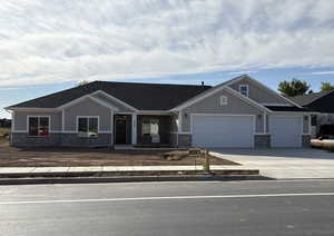 Craftsman-style home with covered porch, driveway, a garage, board and batten siding, and brick siding