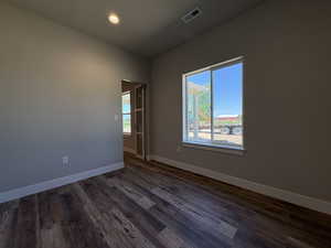 Spare room featuring dark wood-type flooring and recessed lighting