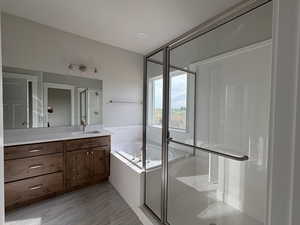 Bathroom with vanity, a shower stall, and a garden tub