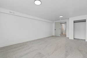 Unfurnished bedroom with light carpet and a closet