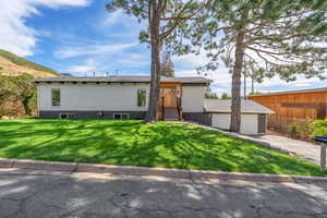 Front of the house featuring a front lawn and a garage