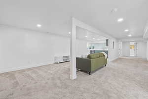 Living area featuring light colored carpet, recessed lighting, and wine cooler