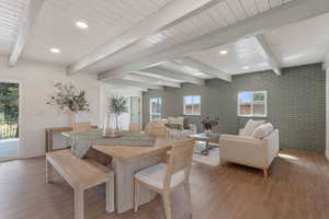 Dining space with recessed lighting, light wood-type flooring, beamed ceiling, and brick wall