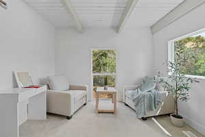 Sitting room with carpet floors and beam ceiling
