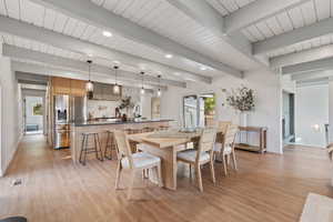 Dining space featuring light wood-style flooring and beam ceiling