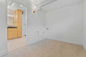 Unfurnished room with light carpet and a wood ceiling with exposed beams