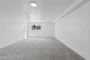 Carpeted empty room with baseboards and a textured ceiling