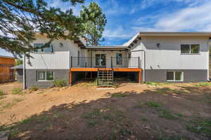 Back of property with stairs and a wooden deck