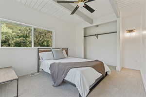Bedroom with carpet, a ceiling fan, and a wood ceiling with exposed beams