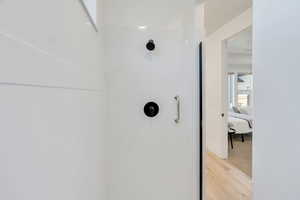 Bathroom view of wood finished floors, ensuite bath shower