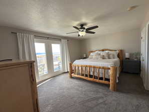Carpeted bedroom featuring access to exterior, a textured ceiling, and a ceiling fan
