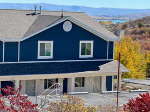 View of front of property with roof with shingles, a mountain view, and a porch